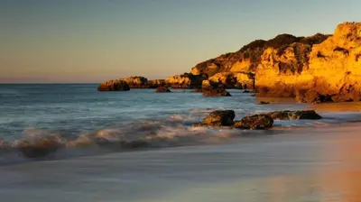 a beach with rocks in the water and the ocean at Buganvilia by Check-in Portugal in Albufeira