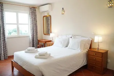 a bedroom with a white bed with two towels on it at Villa Lychee in Guia