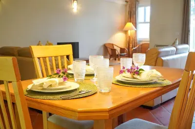 a wooden table with plates and napkins on it at Villa Lychee in Guia