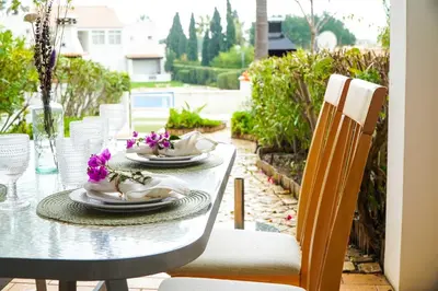 a table with plates and flowers on a patio at Villa Lychee in Guia