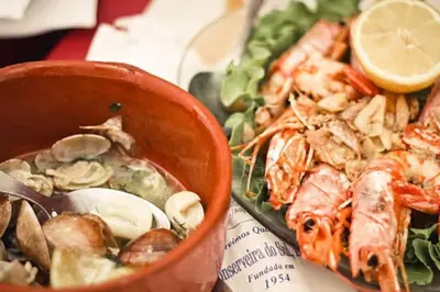 a bowl of seafood on a table with a plate of food at Vacation Apartment in Quarteira in Cavacos