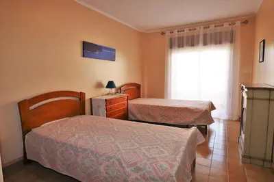 a hotel room with two beds and a window at Vacation Apartment in Quarteira in Cavacos