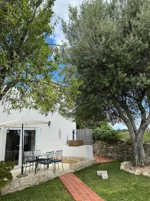 a patio with a table and chairs under an umbrella at Casa Nova Vida in Paderne