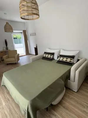 a large green bed in a room with a couch at Casa Nova Vida in Paderne