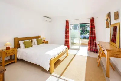 a bedroom with a bed and a desk and a window at Townhouse Flores in Faro