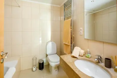 a bathroom with a white toilet and a sink at Townhouse Flores in Faro