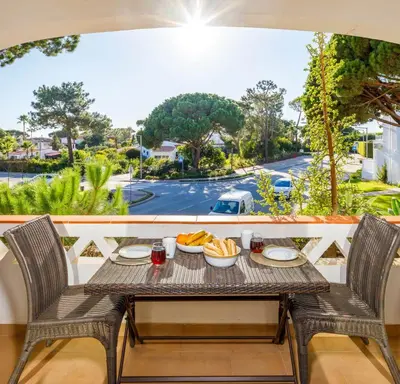a table with food on a balcony with a view of a street at Townhouse Flores in Faro