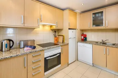 a kitchen with wooden cabinets and white appliances at Townhouse Flores in Faro