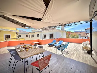a patio with a table and chairs and an umbrella at Vilamoura Central 8 by Homing in Vilamoura