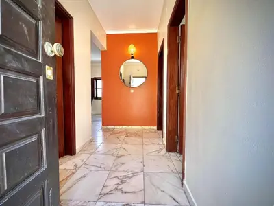 a hallway with an orange wall and a mirror at Vilamoura Central 8 by Homing in Vilamoura