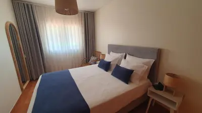 a bedroom with a bed with blue and white pillows at Villa Falésia casa da Sobreira in Albufeira