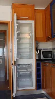 an empty refrigerator with its door open in a kitchen at Villa Falésia casa da Sobreira in Albufeira