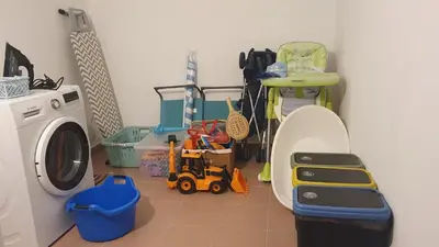 a laundry room with a washing machine and toys in it at Villa Falésia casa da Sobreira in Albufeira