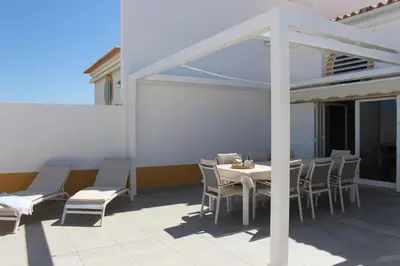 a patio with a table and chairs on a patio at Villa Falésia casa da Sobreira in Albufeira