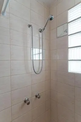 a shower with a shower head in a bathroom at Blife Alicya private rooms in Faro
