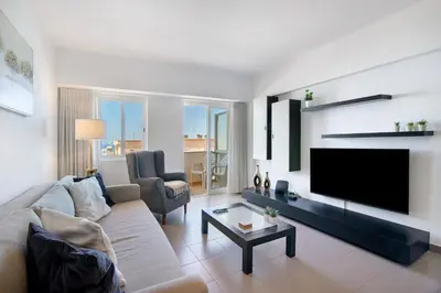 a living room with a couch and a flat screen tv at Moderno e acolhedor com vista mar in Quarteira