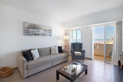 a living room with a couch and a table at Moderno e acolhedor com vista mar in Quarteira