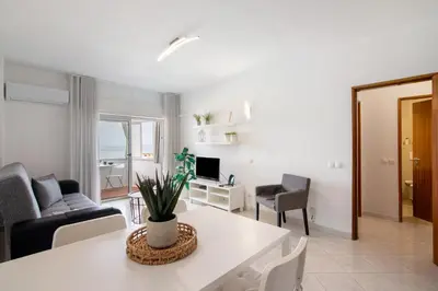 a living room with a couch and a table at T1 com vista mar in Quarteira