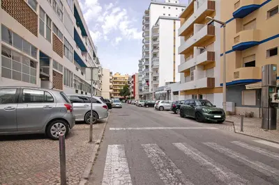 a street with cars parked on the side of the road at T1 com vista mar in Quarteira