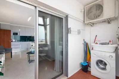 a kitchen and living room with a washer and dryer at T1 com vista mar in Quarteira