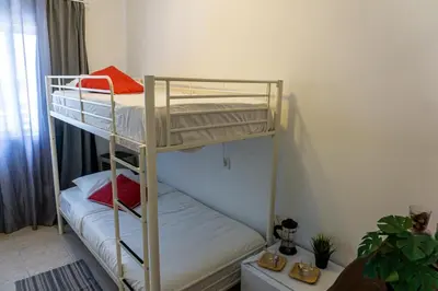 a bedroom with two bunk beds in a room at Aconchego de quartos no centro de Faro in Faro
