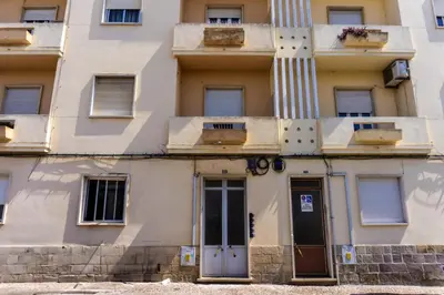 a building with a column and a door at Aconchego de quartos no centro de Faro in Faro