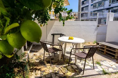 a table and chairs sitting on a rooftop patio at Aconchego de quartos no centro de Faro in Faro
