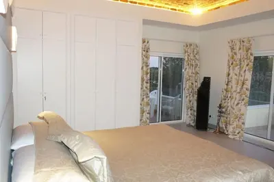 a bedroom with a large bed with white walls and windows at Luxury Private 5 bedroom Villa pool, golf, Algarve in Quarteira