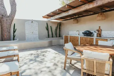 an outdoor patio with a wooden table and chairs at Casa Ana Almancil in Almancil