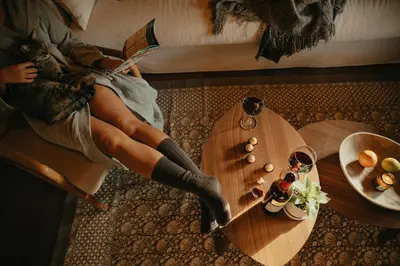a woman in boots sitting on a couch with a table at Casa Ana Almancil in Almancil