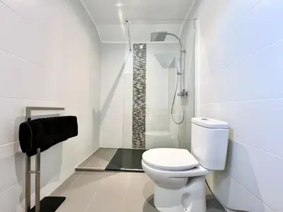 a white bathroom with a shower and a toilet at Home Out - Vilamoura Beach Apartment - Duplex in Quarteira