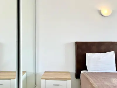 a bedroom with a bed and a wooden headboard at Home Out - Vilamoura Beach Apartment - Duplex in Quarteira