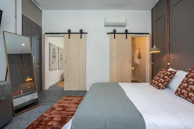 a bedroom with a large white bed and a television at Dona Simone Boutique Suites & Studios - by @ rita's place in Faro