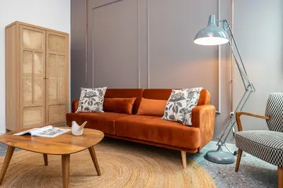 a living room with an orange couch and a table at Dona Simone Boutique Suites & Studios - by @ rita's place in Faro