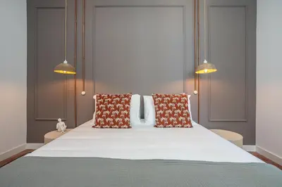 a bedroom with a large white bed with two pillows at Dona Simone Boutique Suites & Studios - by @ rita's place in Faro