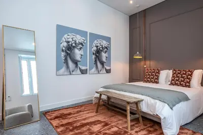 a bedroom with a king sized bed and a painting at Dona Simone Boutique Suites & Studios - by @ rita's place in Faro