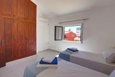 a bedroom with two beds and a window at Townhouse in Quarteira in Quarteira
