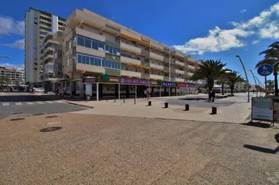 an empty city street with a large building at Townhouse in Quarteira in Quarteira