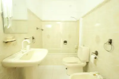 a white bathroom with a toilet and a sink at Townhouse in Quarteira in Quarteira