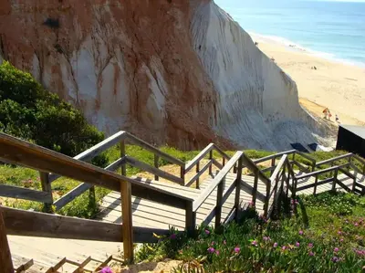 a set of wooden stairs leading to a beach at Calm Sunny Apartment near Falésia Beach in Albufeira