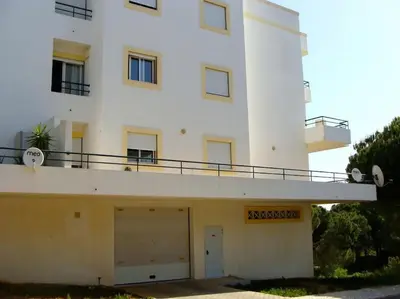 a white building with a garage in front of it at Calm Sunny Apartment near Falésia Beach in Albufeira