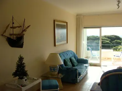 a living room with a blue couch and a table at Calm Sunny Apartment near Falésia Beach in Albufeira