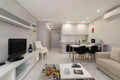 a white living room with a couch and a table at ALICE - Vilamoura in Vilamoura