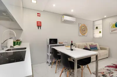 a kitchen and living room with a table and a couch at ALICE - Vilamoura in Vilamoura
