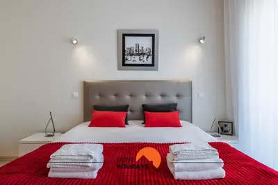 a bedroom with a large bed with red pillows at #226 Vila LII by Home Holidays in Albufeira