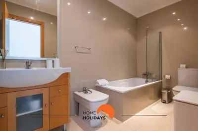 a bathroom with a sink and a tub and a toilet at #226 Vila LII by Home Holidays in Albufeira