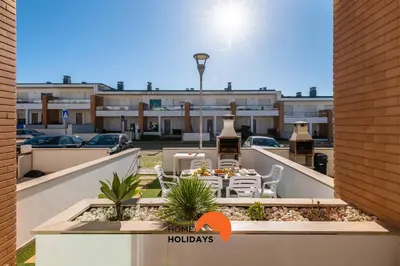 a balcony with a table and chairs in a parking lot at #226 Vila LII by Home Holidays in Albufeira