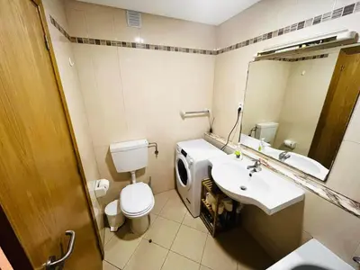 a bathroom with a toilet and a sink and a mirror at Pe do Lago cosy apartment in Quarteira