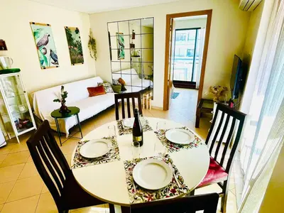a dining room with a white table and chairs at Pe do Lago cosy apartment in Quarteira