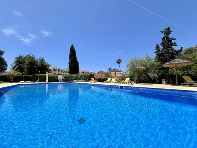 a large blue swimming pool with chairs and umbrellas at Albufeira Tropical View 1 With Pool by Homing in Albufeira
